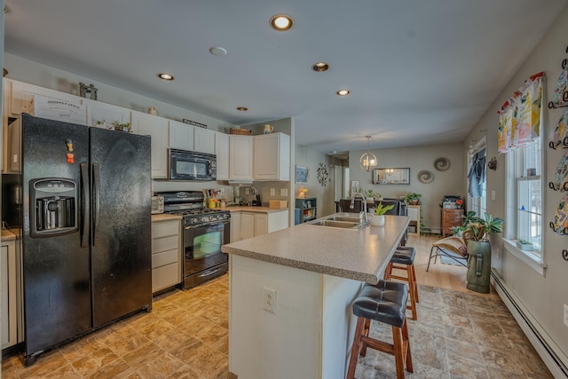 kitchen featuring a sink, black appliances, light countertops, white cabinetry, and baseboard heating