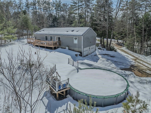 snow covered rear of property with a deck