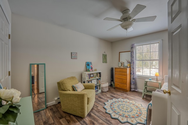 sitting room with wood finished floors, baseboards, baseboard heating, and ceiling fan