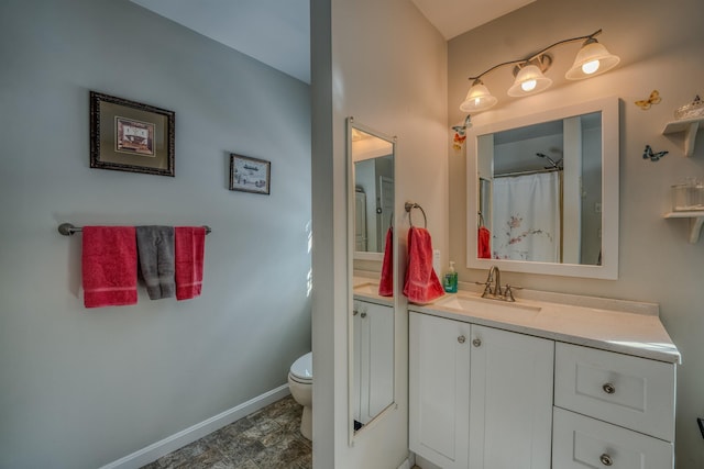 full bath featuring toilet, vanity, and baseboards