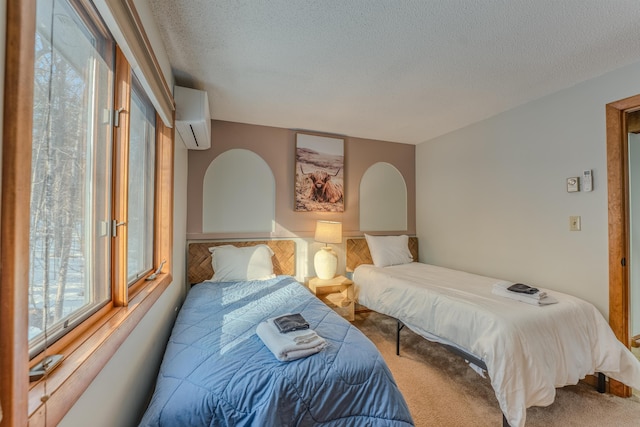 carpeted bedroom with a textured ceiling and a wall mounted AC