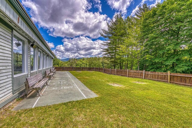 view of yard with shuffleboard and fence