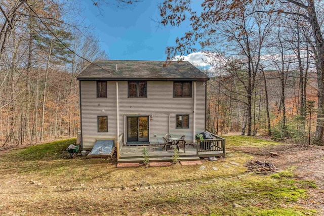 rear view of house featuring a lawn and a deck