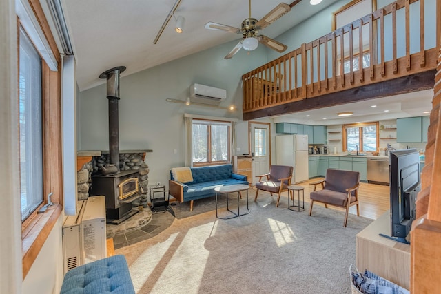 living area featuring high vaulted ceiling, an AC wall unit, a ceiling fan, track lighting, and a wood stove