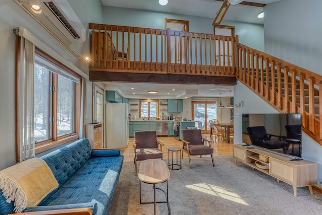 living area with stairway, a towering ceiling, and a wall mounted AC