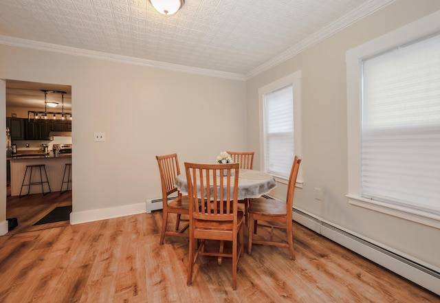 dining area with light wood-style flooring, ornamental molding, baseboards, and a baseboard radiator