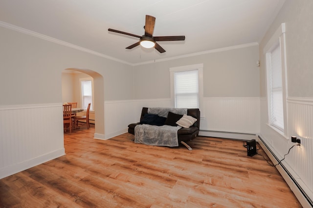 living area with a wainscoted wall, a healthy amount of sunlight, and arched walkways