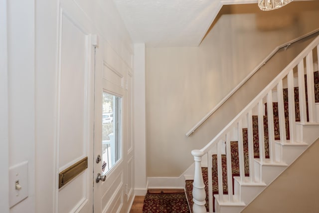 foyer entrance featuring stairway, wood finished floors, and baseboards