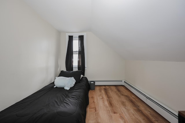 bedroom featuring vaulted ceiling, wood finished floors, and baseboard heating