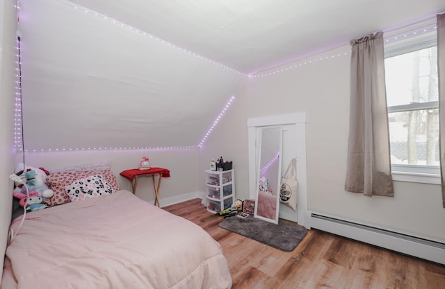 bedroom featuring a baseboard radiator, wood finished floors, and vaulted ceiling