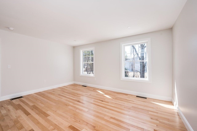 unfurnished room featuring visible vents, baseboards, and light wood-style floors