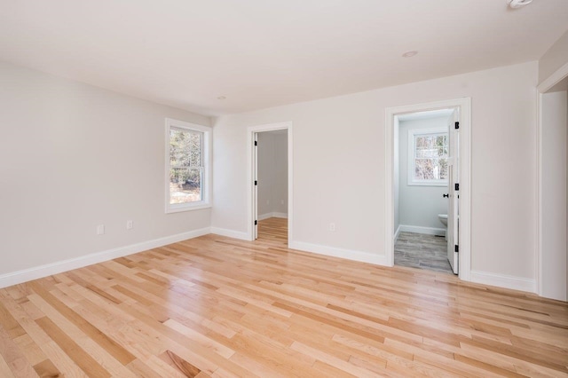 spare room featuring light wood-style floors and baseboards