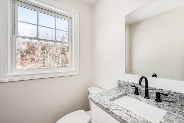 bathroom featuring a healthy amount of sunlight, toilet, and vanity