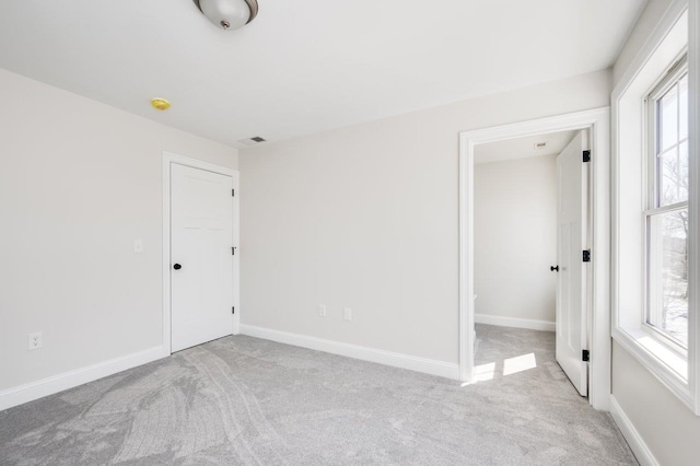 carpeted empty room featuring visible vents and baseboards