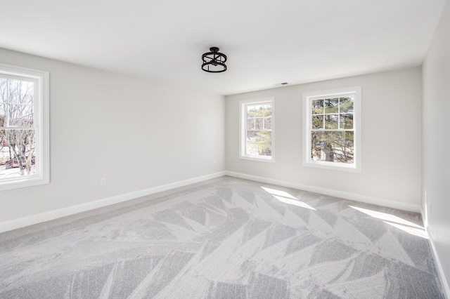 carpeted spare room featuring visible vents and baseboards