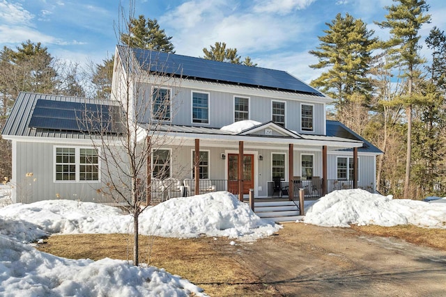 view of front of house featuring roof mounted solar panels and covered porch