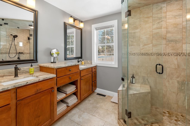 bathroom with double vanity, a stall shower, visible vents, and a sink