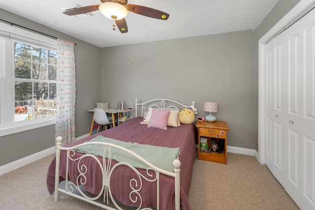 bedroom featuring multiple windows, baseboards, a closet, and ceiling fan