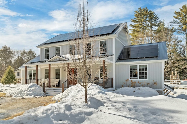 view of front of house featuring solar panels, a porch, and board and batten siding