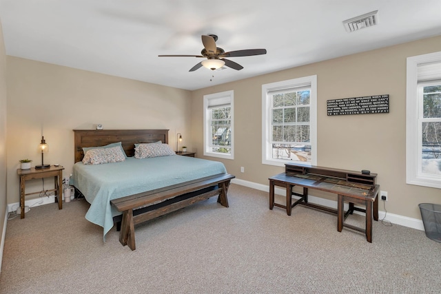 bedroom featuring visible vents, light carpet, and multiple windows