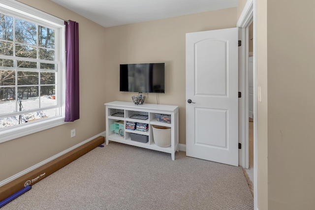 interior space featuring light colored carpet and baseboards