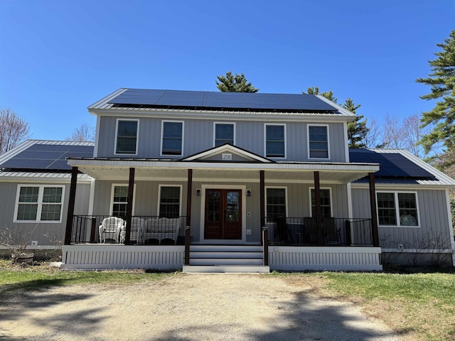 258 Odell Hill Rd, Conway, NH 03813 - view of front facade with covered porch, board and batten siding, solar panels, and metal roof