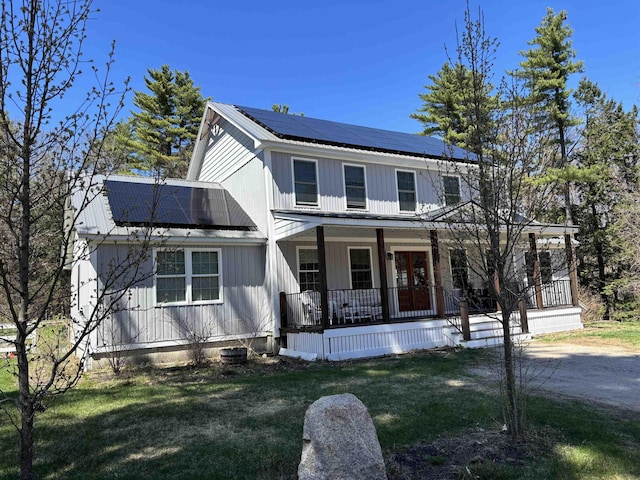 258 Odell Hill Rd, Conway, NH 03813 - view of front of home with covered porch, metal roof, roof mounted solar panels, and a front yard