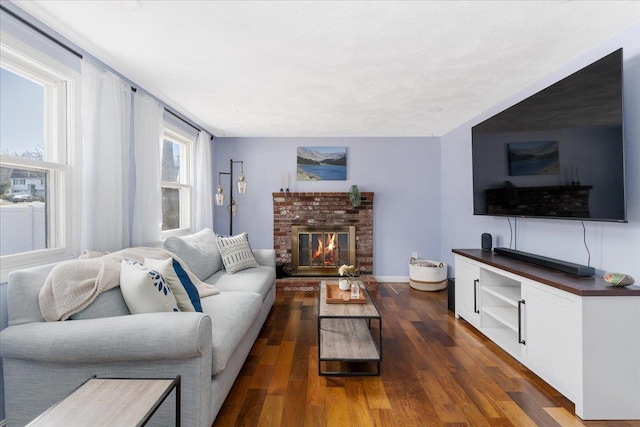 living room featuring baseboards, dark wood finished floors, and a fireplace