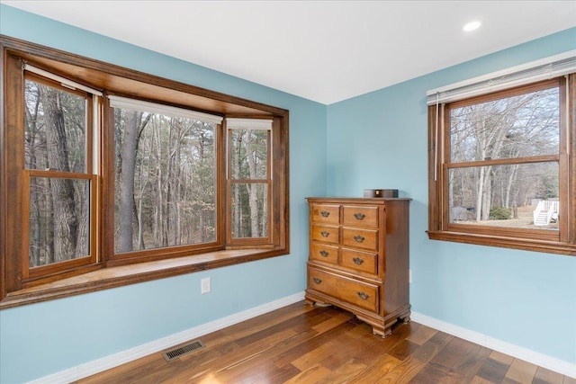 unfurnished room featuring dark wood-type flooring, recessed lighting, baseboards, and visible vents