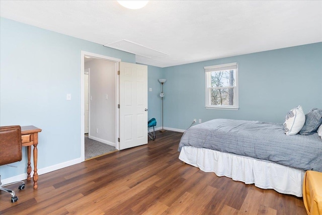 bedroom with baseboards, attic access, and wood finished floors