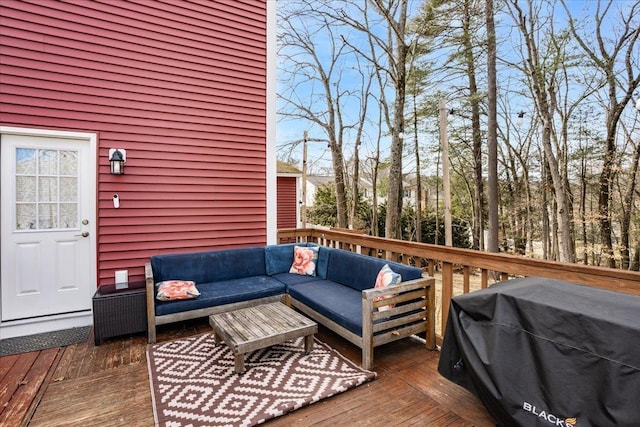 wooden deck with an outdoor living space and area for grilling