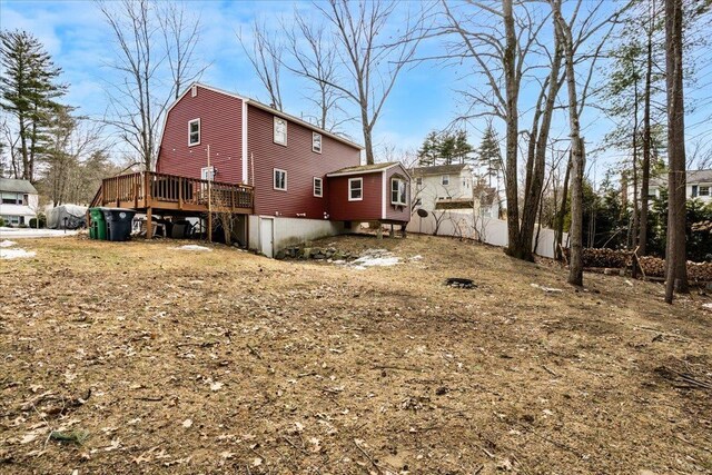 rear view of house featuring a wooden deck and fence