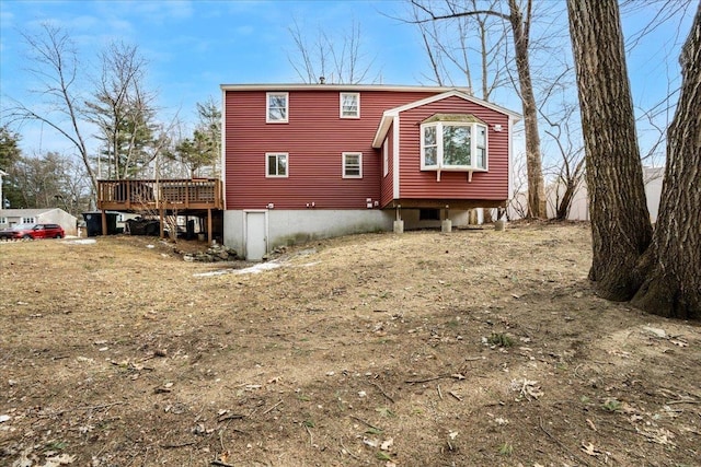 rear view of property featuring a wooden deck