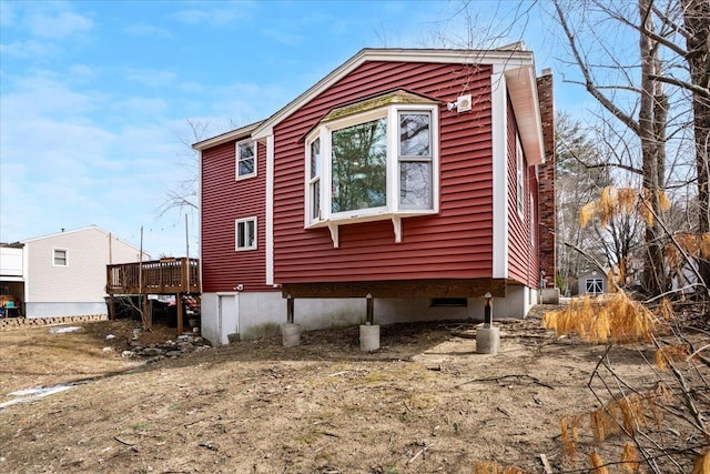 view of side of home featuring a wooden deck and a chimney