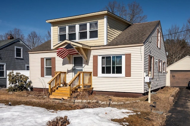 view of front of home featuring an outbuilding and roof with shingles