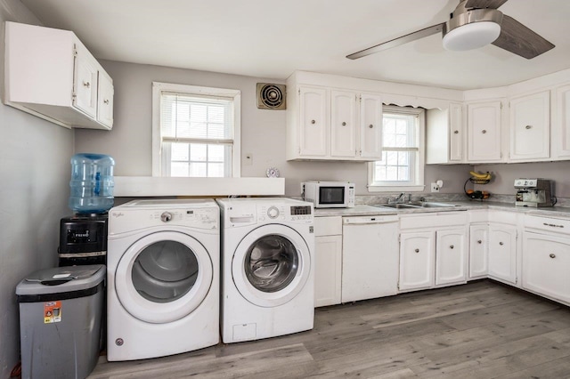 laundry area with wood finished floors, a ceiling fan, laundry area, a sink, and washer and dryer