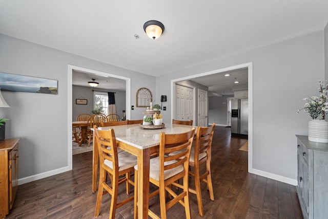 dining area with dark wood finished floors and baseboards