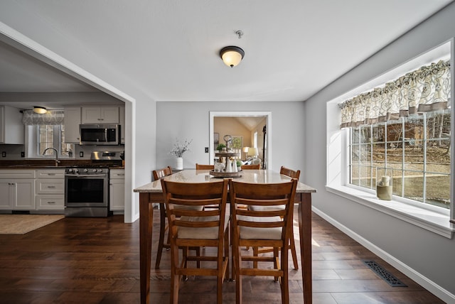 dining area with visible vents, baseboards, and dark wood finished floors