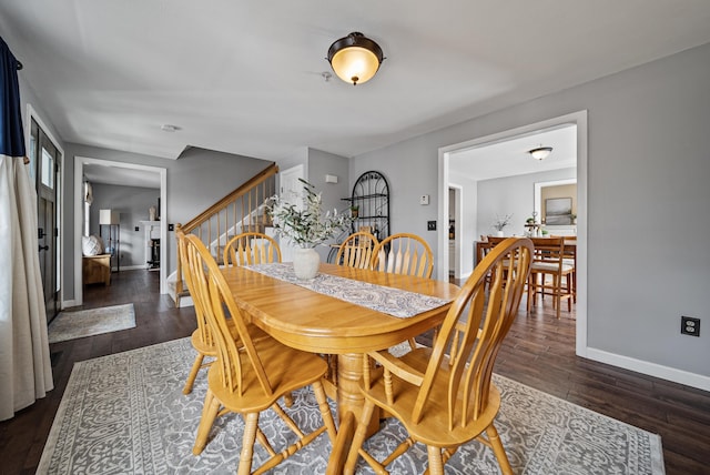 dining space featuring stairway, baseboards, and dark wood-style flooring