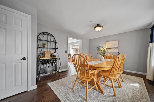 dining area featuring dark wood-type flooring and baseboards