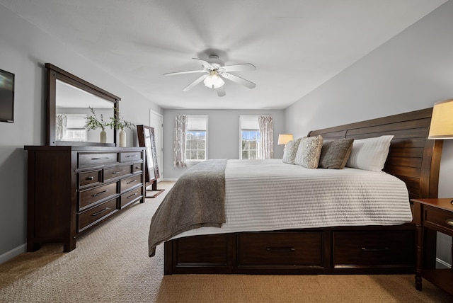 bedroom featuring light colored carpet, a ceiling fan, and baseboards