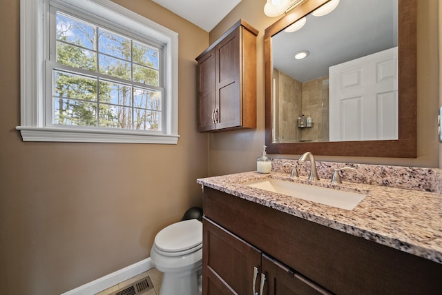 full bathroom featuring vanity, visible vents, baseboards, a tile shower, and toilet