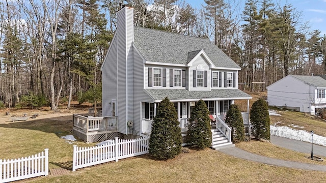 view of front of property with fence, roof with shingles, a porch, a chimney, and a front lawn