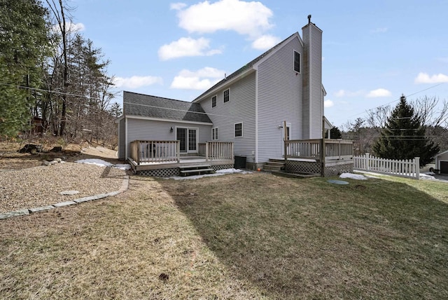 back of property with a wooden deck, a lawn, a chimney, and fence