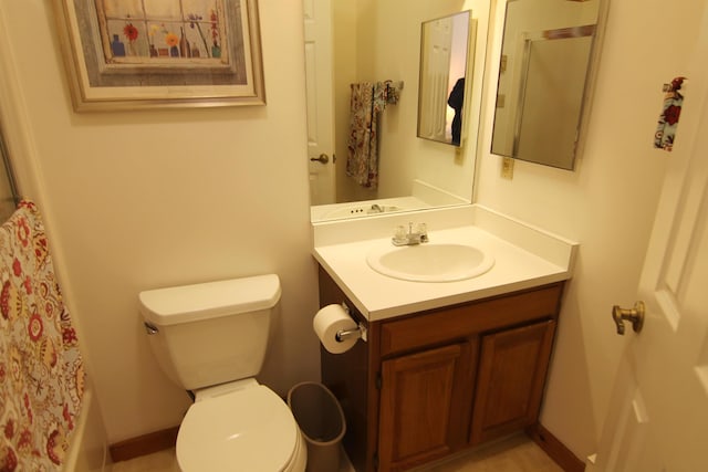 bathroom with toilet, vanity, and a shower with curtain