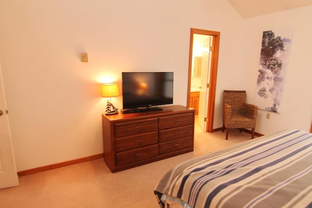 bedroom featuring light colored carpet, baseboards, connected bathroom, and lofted ceiling