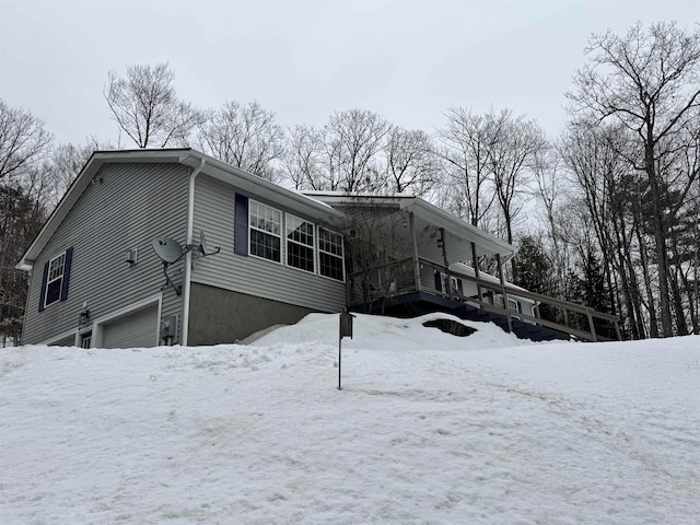 view of snow covered exterior with an attached garage