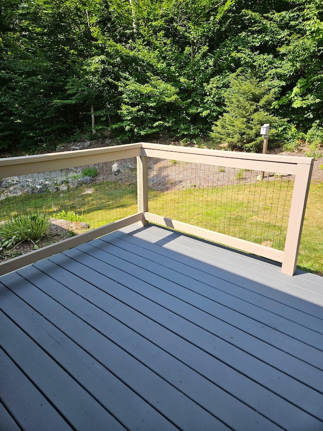 wooden terrace featuring a lawn