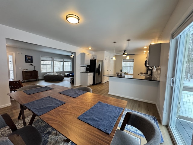 dining area featuring baseboards, a ceiling fan, and wood finished floors