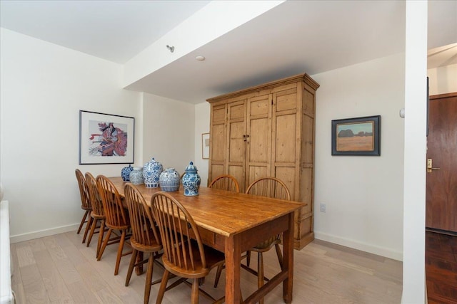 dining space featuring baseboards and light wood-style floors